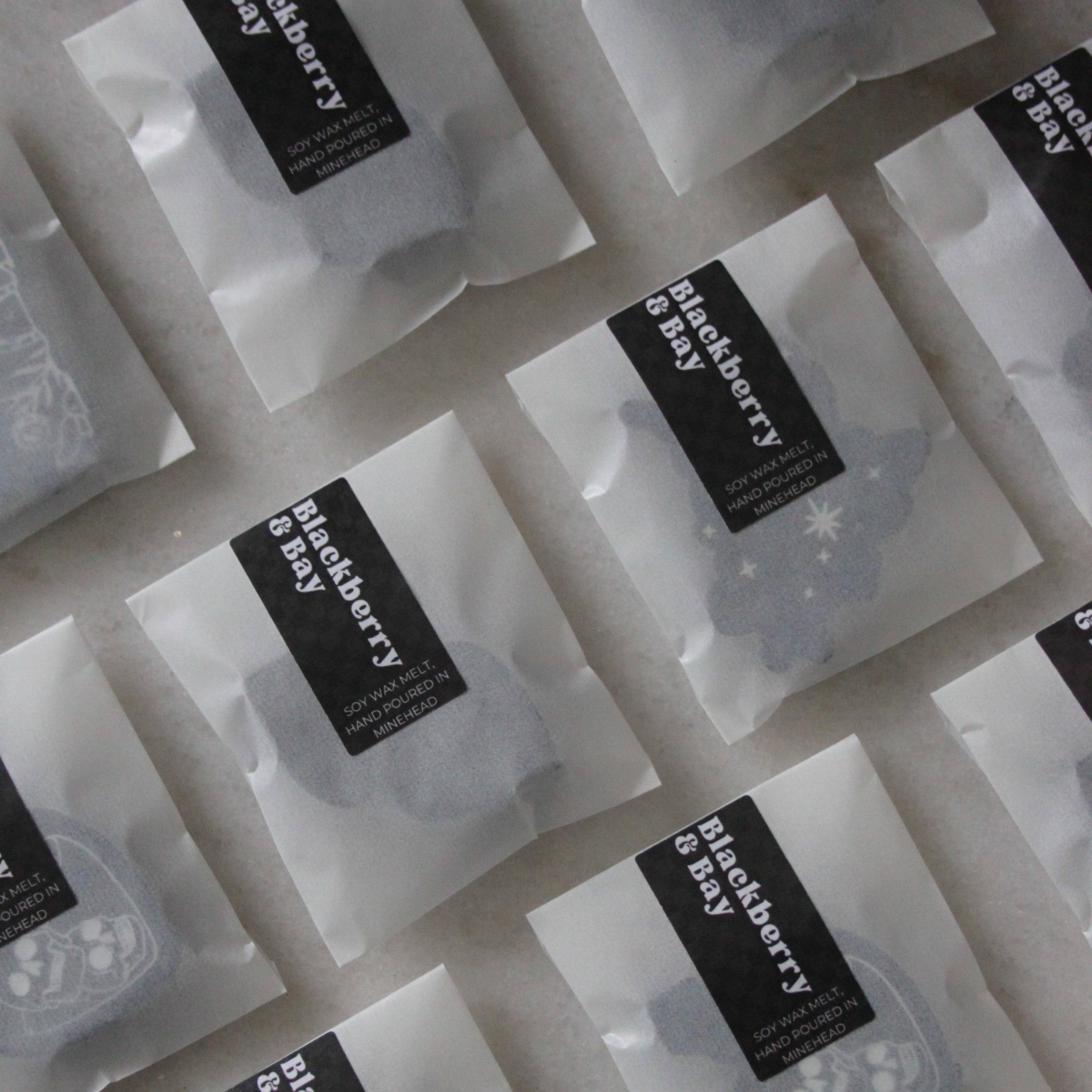 Multiple Blackberry & Bay wax melt samples in white packaging on a marble surface.
